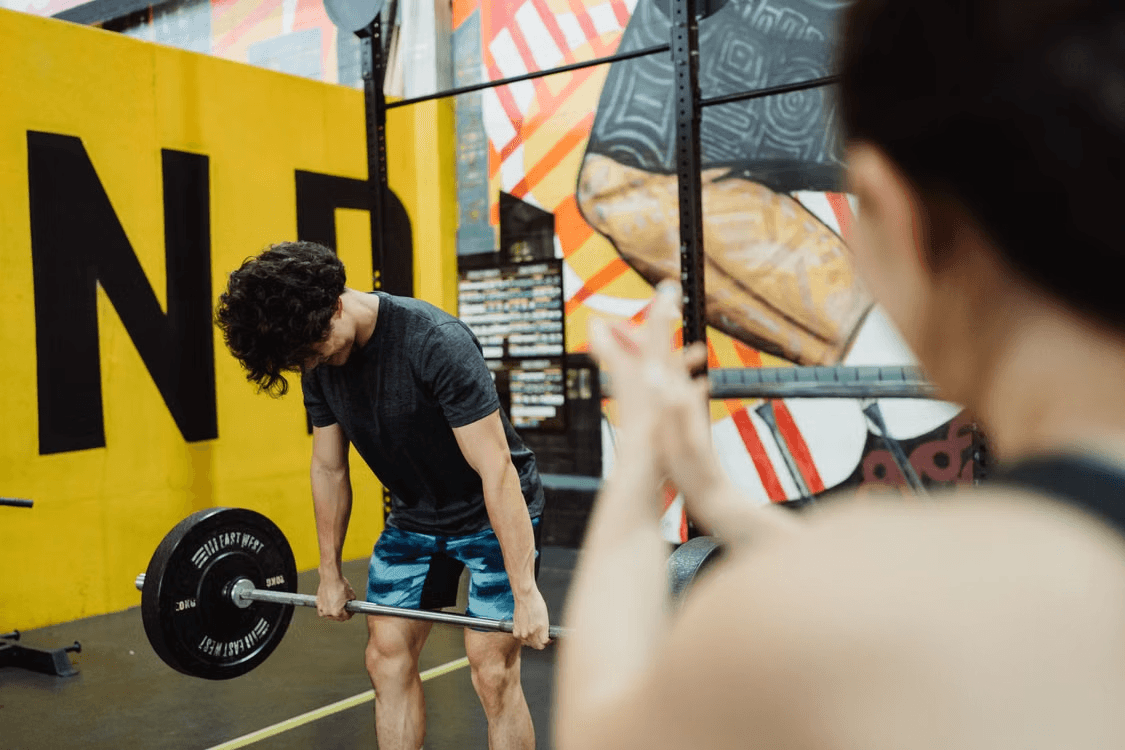 A coach watching an athlete deadlift